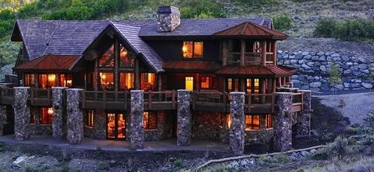 Log home with stone columns and a translucent wood finish